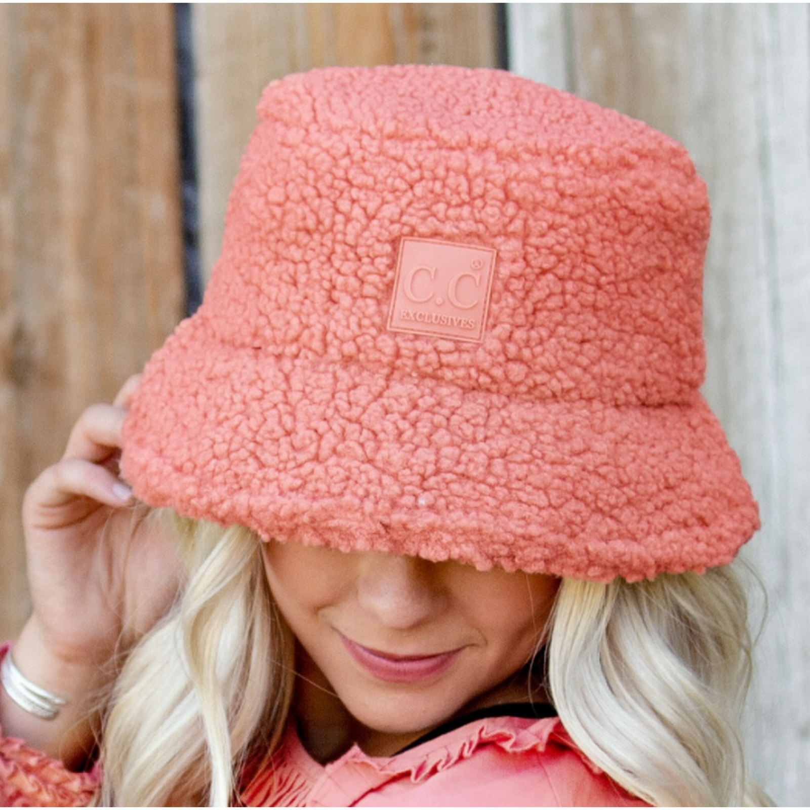 Person wearing a mauve sherpa bucket hat with a visible C.C brand logo.