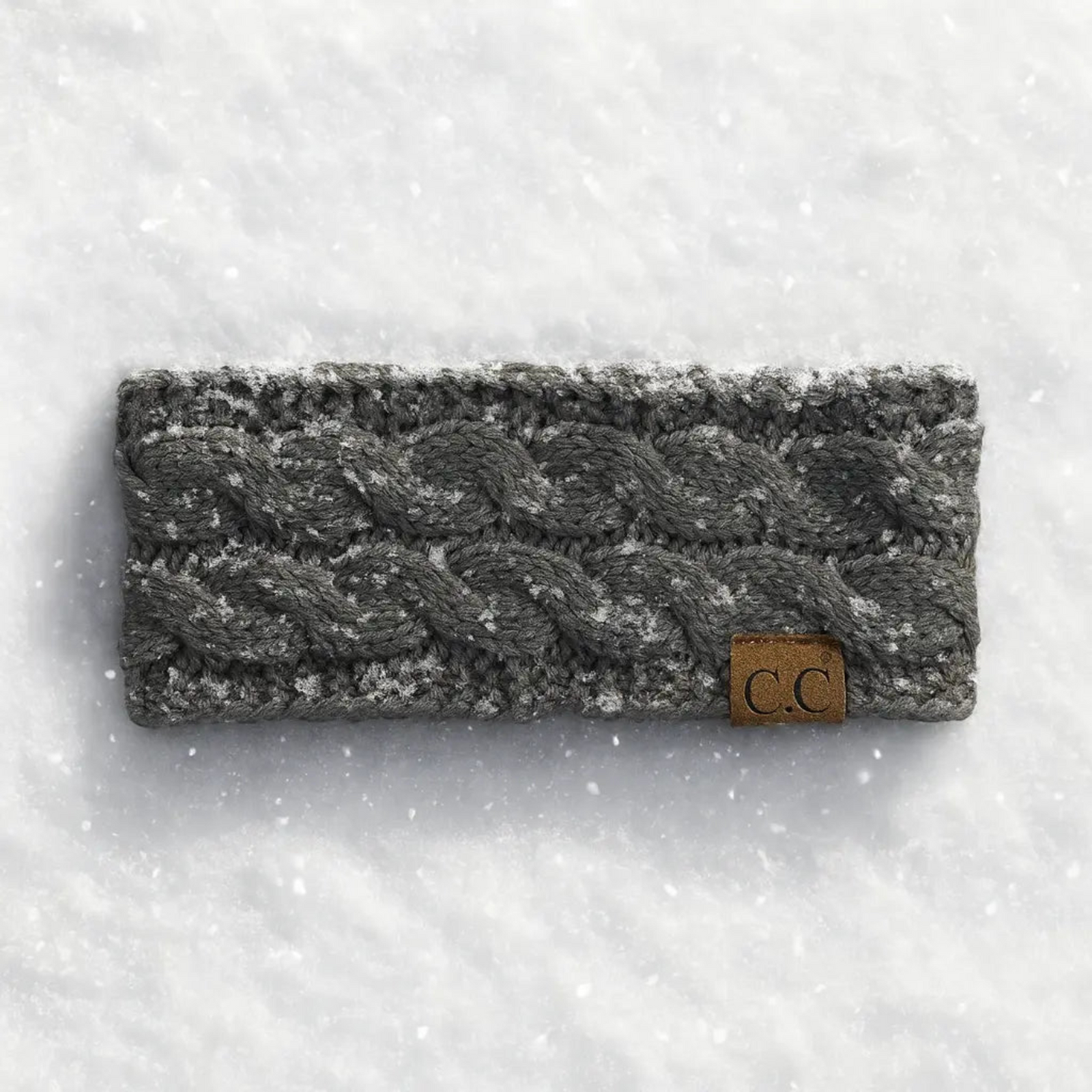 Gray knitted headband with a brand label on a snowy background