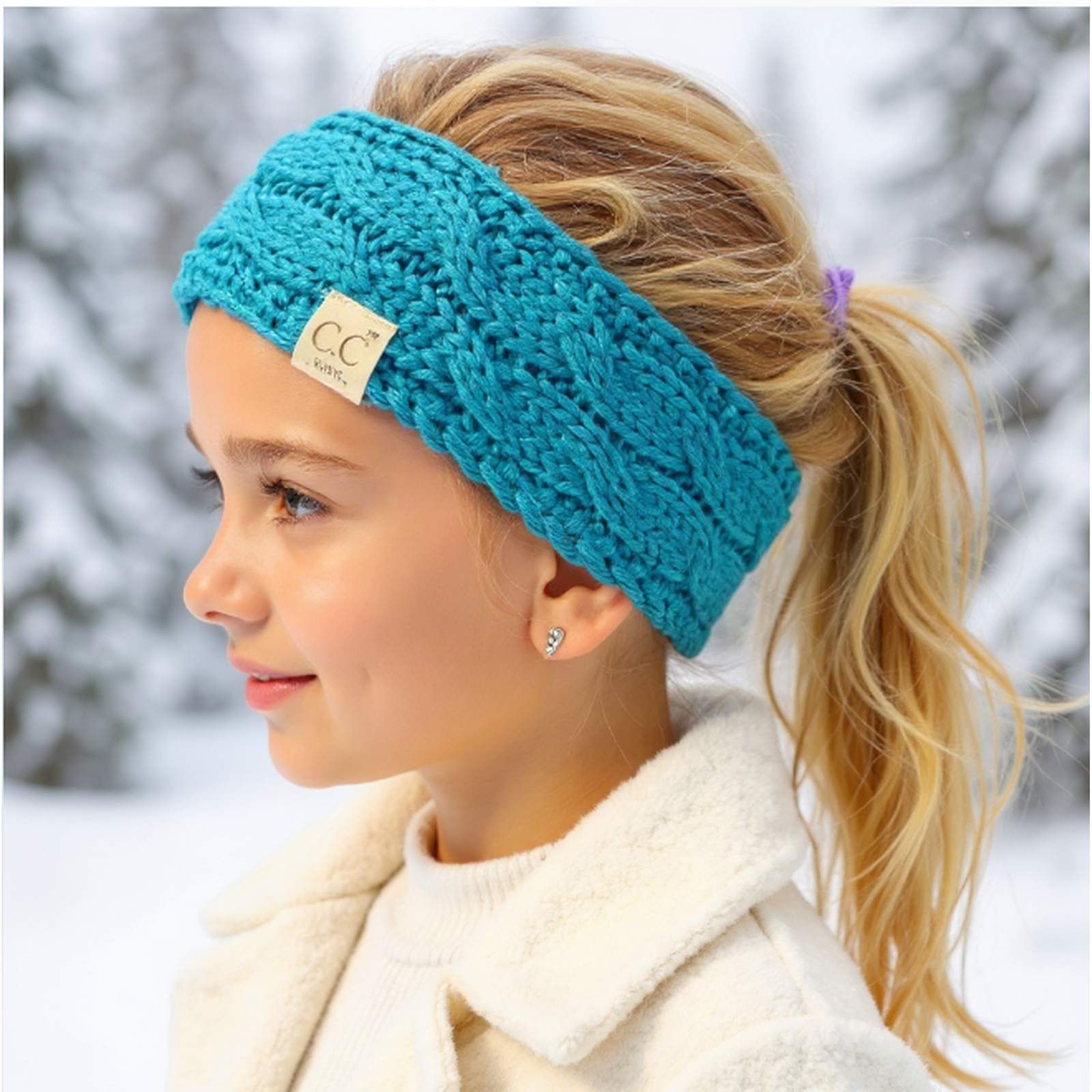 Woman wearing a blue knitted headband with a brand logo in a snowy background