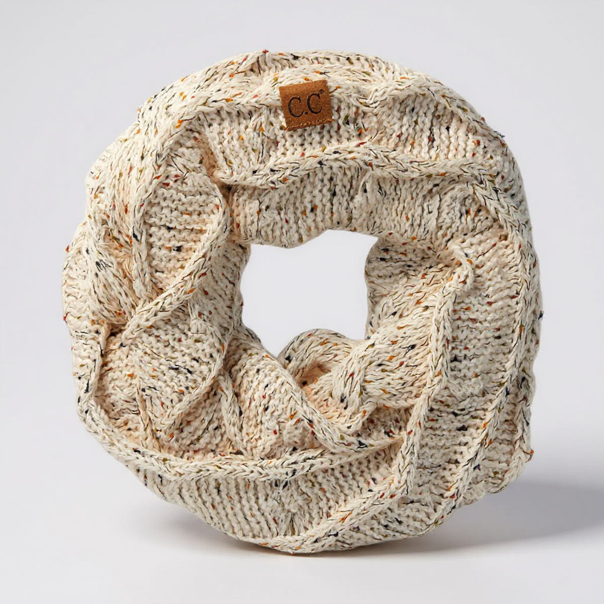 Knitted beige scarf with a c.c brand label on a light gray background
