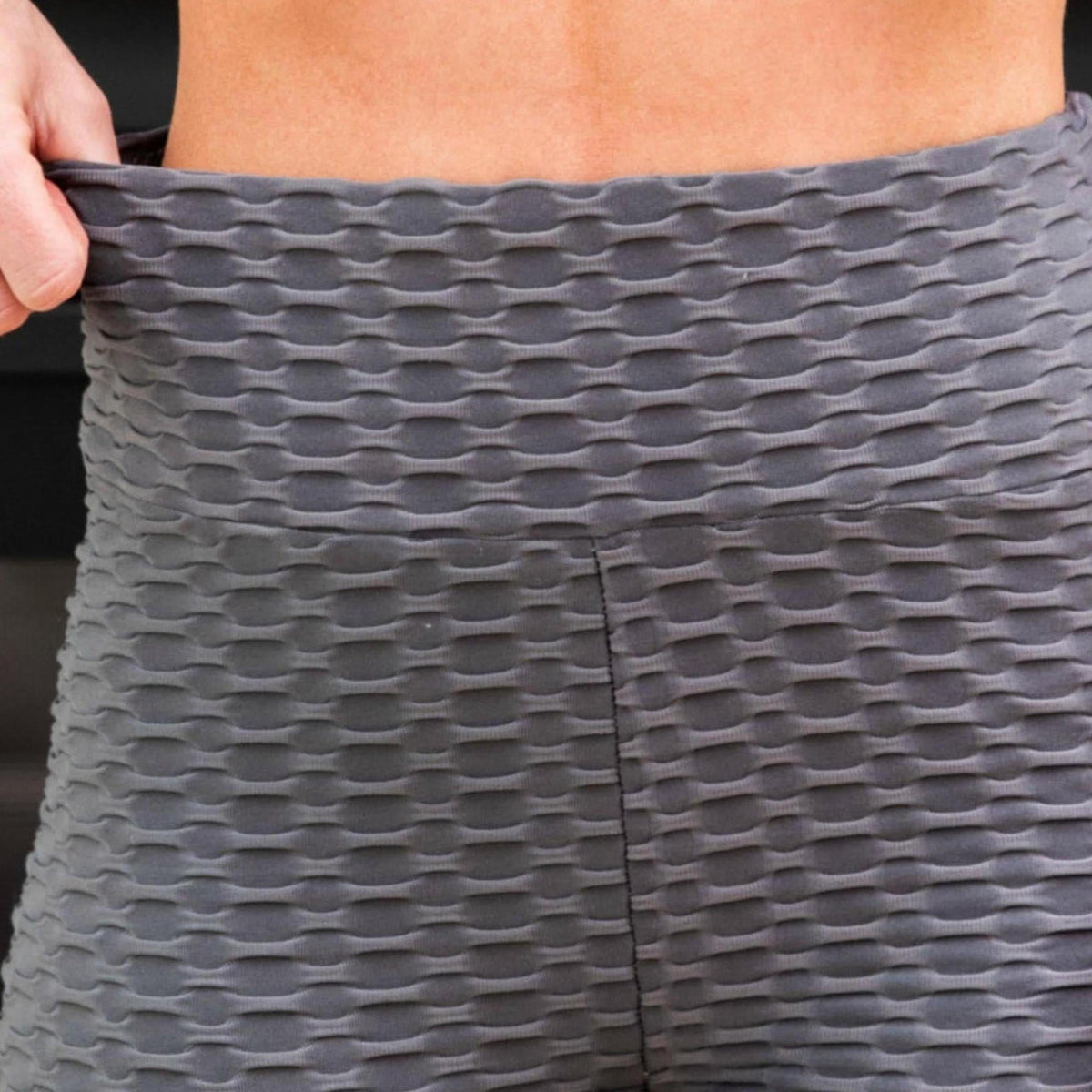 Person wearing gray patterned leggings with a blurred background