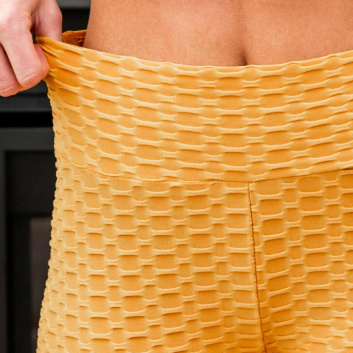 Person wearing mustard yellow leggings with a blurred background